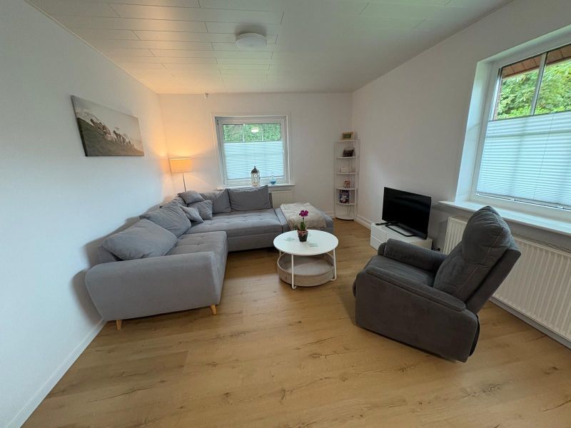 Wohnzimmer mit Sofa, Sessel und Fernseher